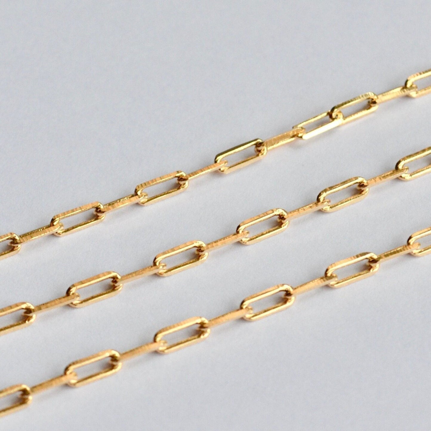 Gold paperclip chain on a light gray background