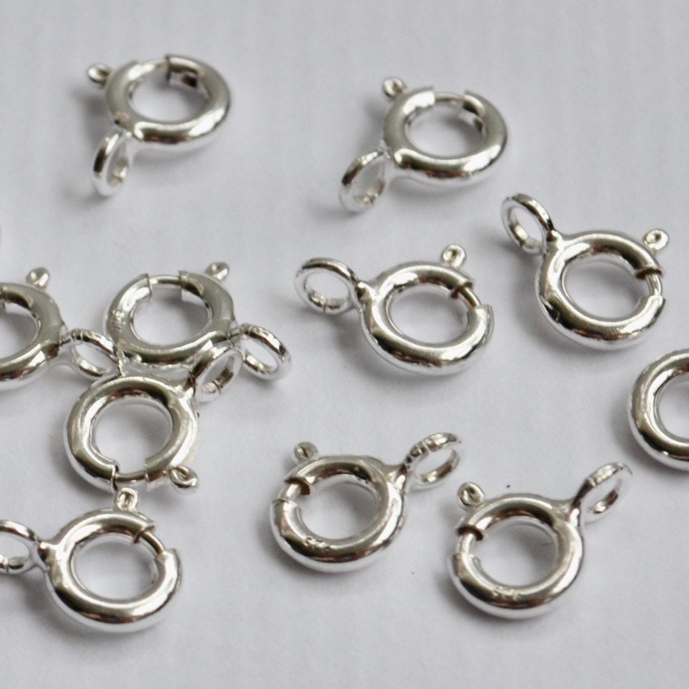 925 sterling Silver spring clasp components on a light gray background