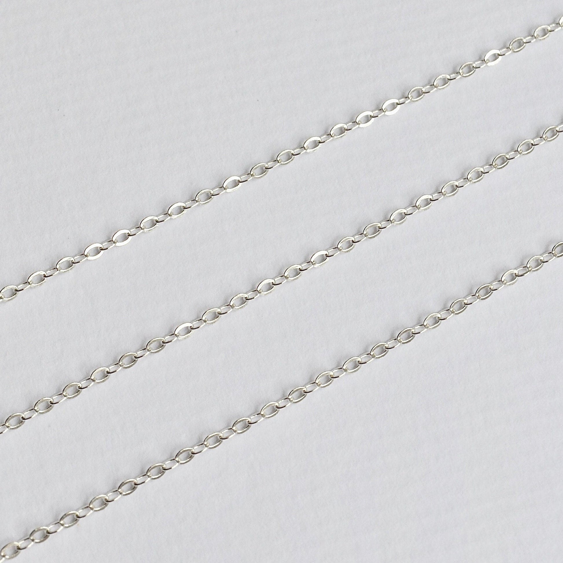 Silver cable chain on a light gray background