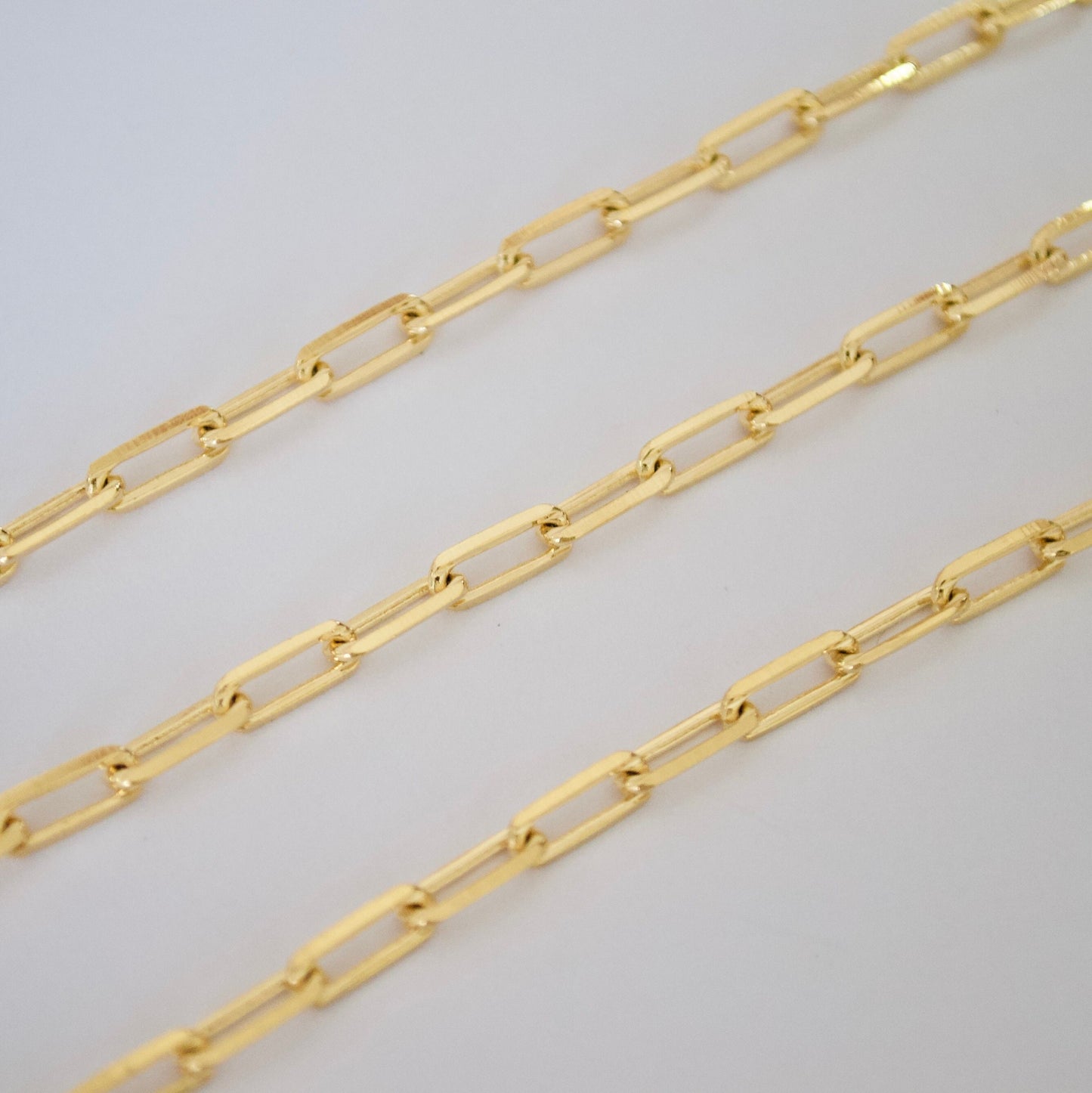 14k Gold filled paper clip chain on a light gray background