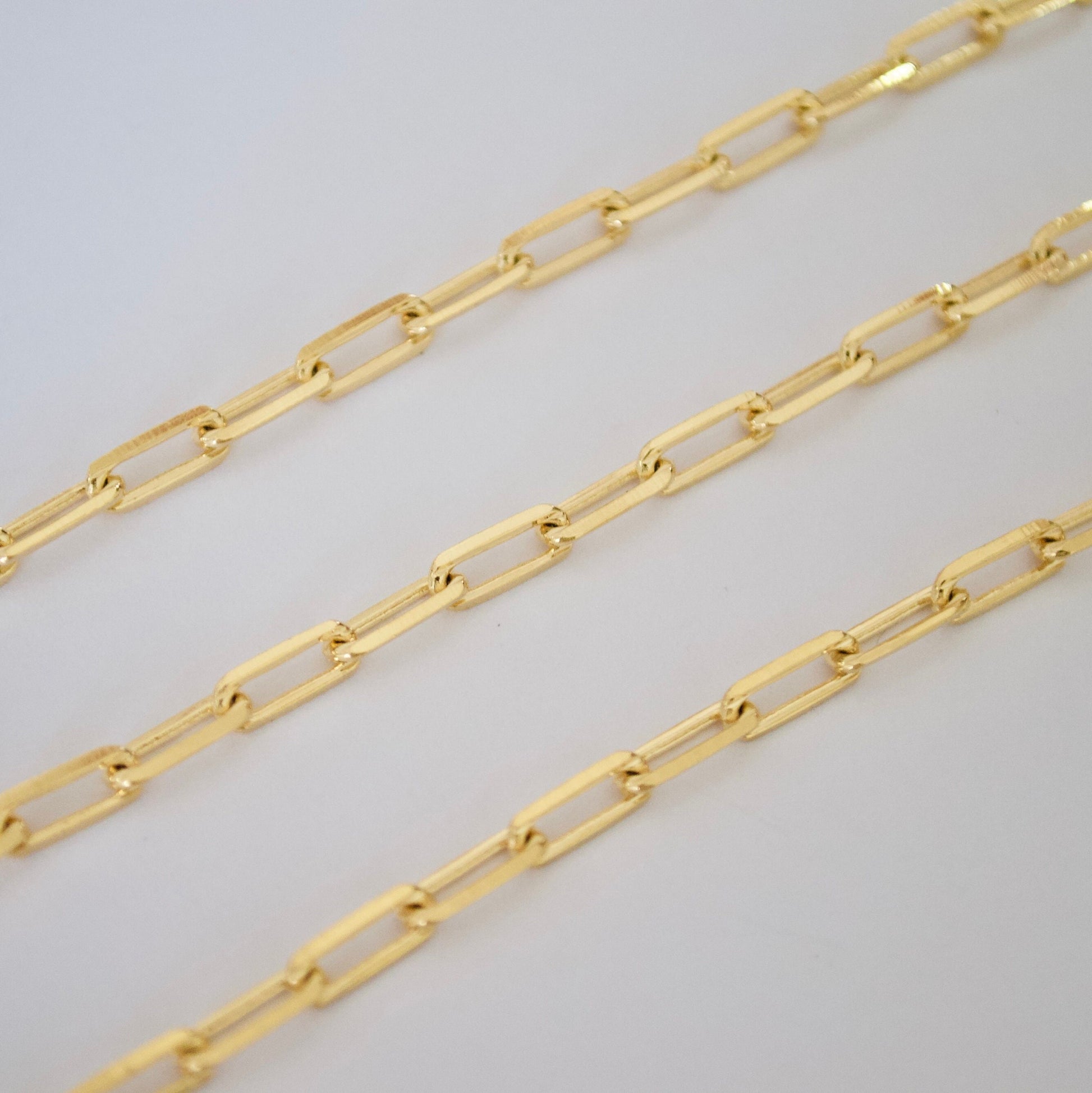 14k Gold filled paper clip chain on a light gray background