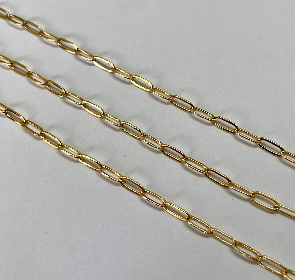 A gold paperclip chain running diagonally across a light gray background.