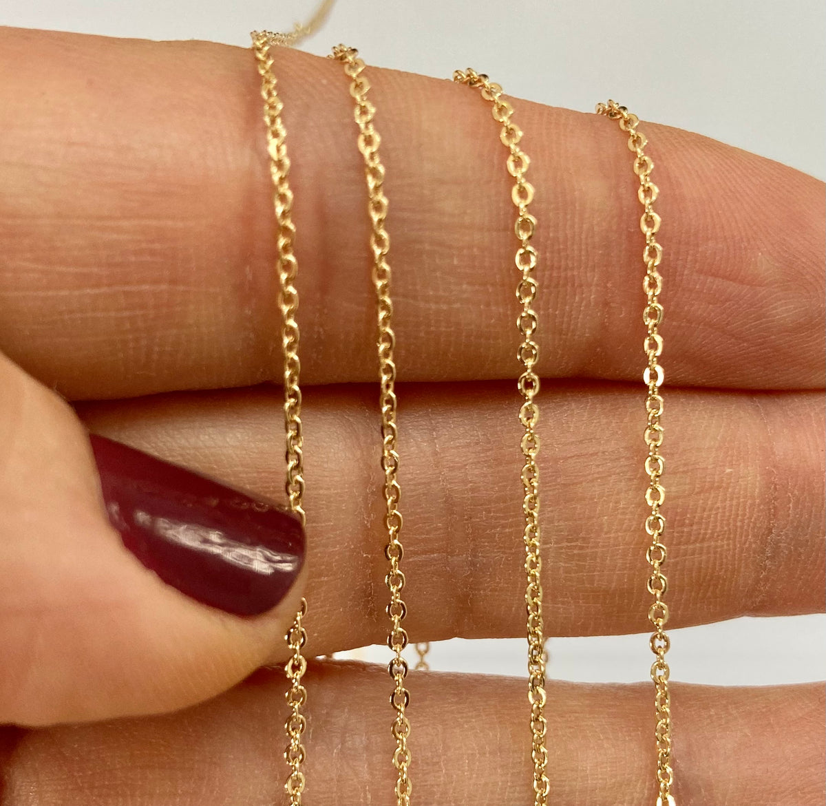 Tiny gold filled cable chain of a hand 