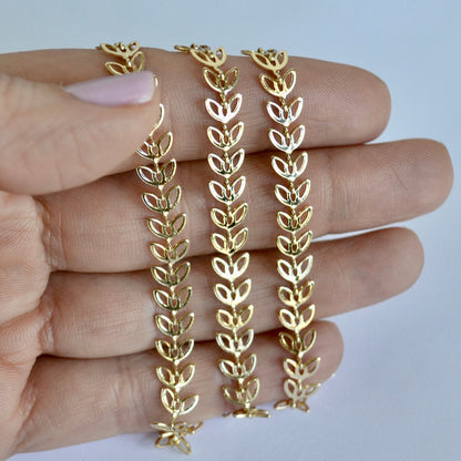 Gold filled leaf-shaped chain held between fingers against a light background