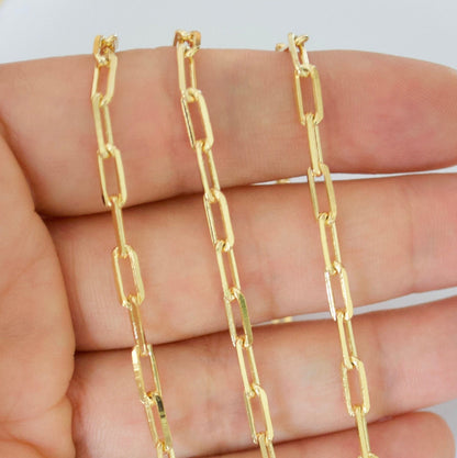 14k Gold filled paperclip chain held between fingers against a white background