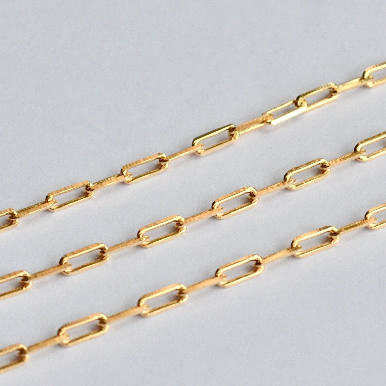 Gold paperclip chain on a light gray background