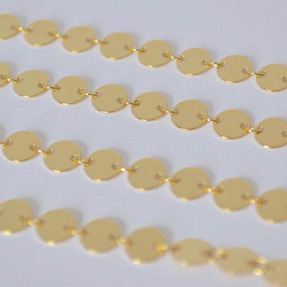 Gold filled sequin chain close up on a white background