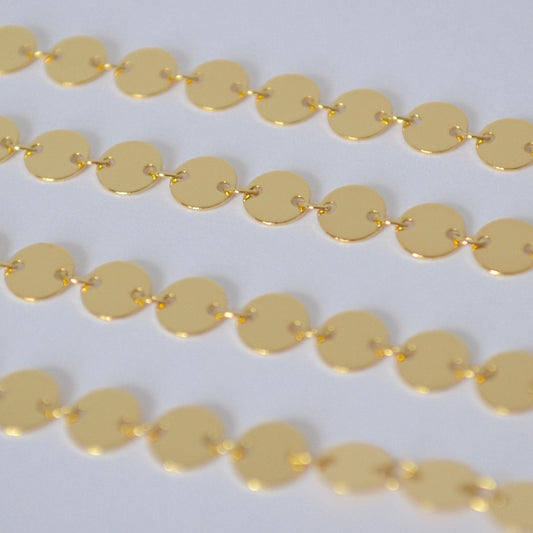 Gold filled sequin chain close up on a white background