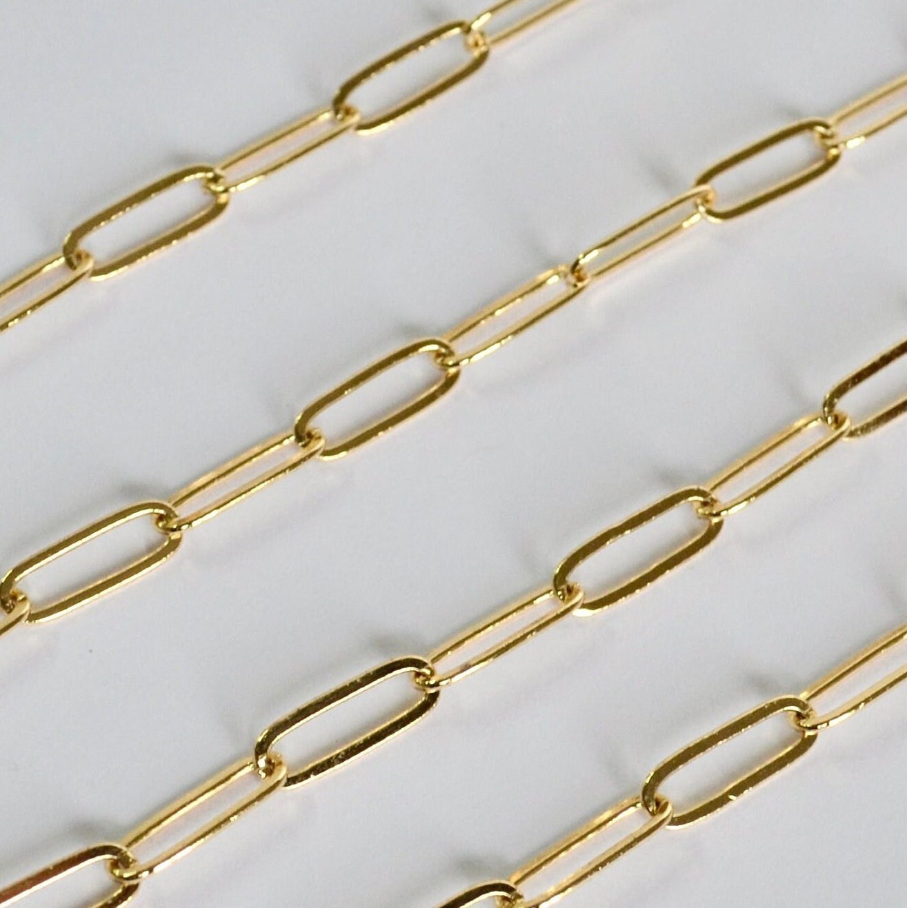 Gold paperclip chain on a white background