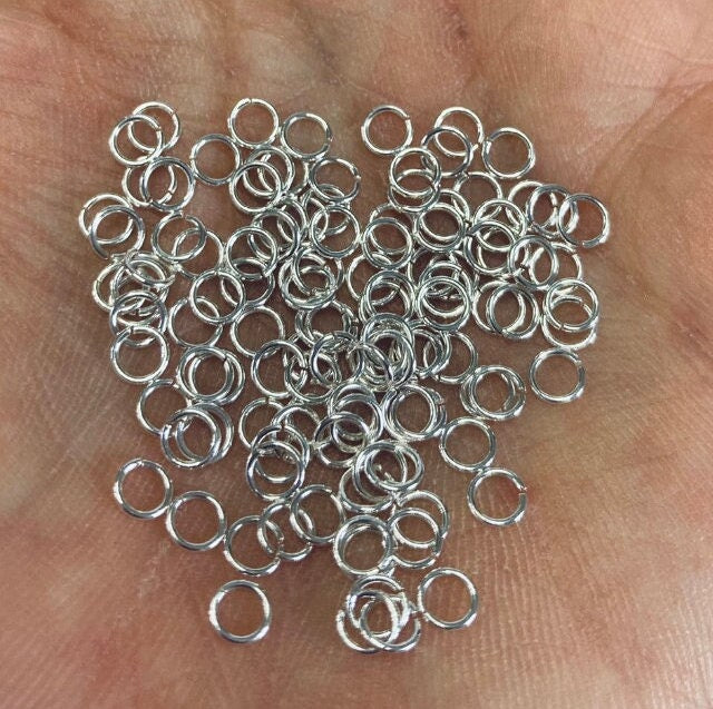 Silver jump rings on a person's palm