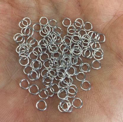 Silver jump rings on a person's palm
