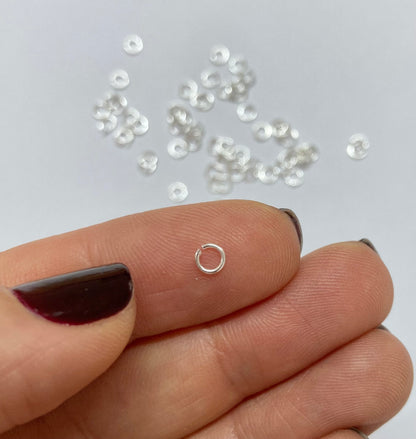 Tiny sterling silver jump ring on a finger