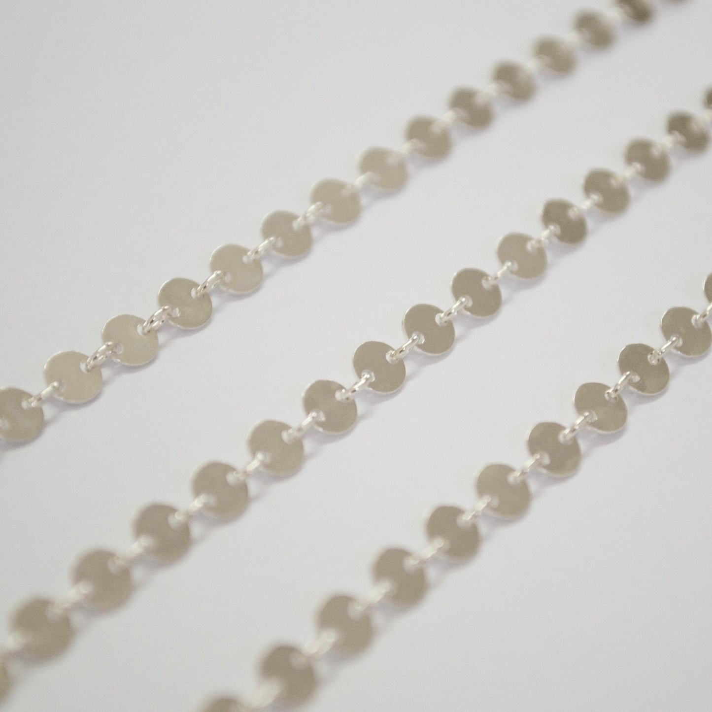Close-up of a sterling silver circle chain on a light gray background
