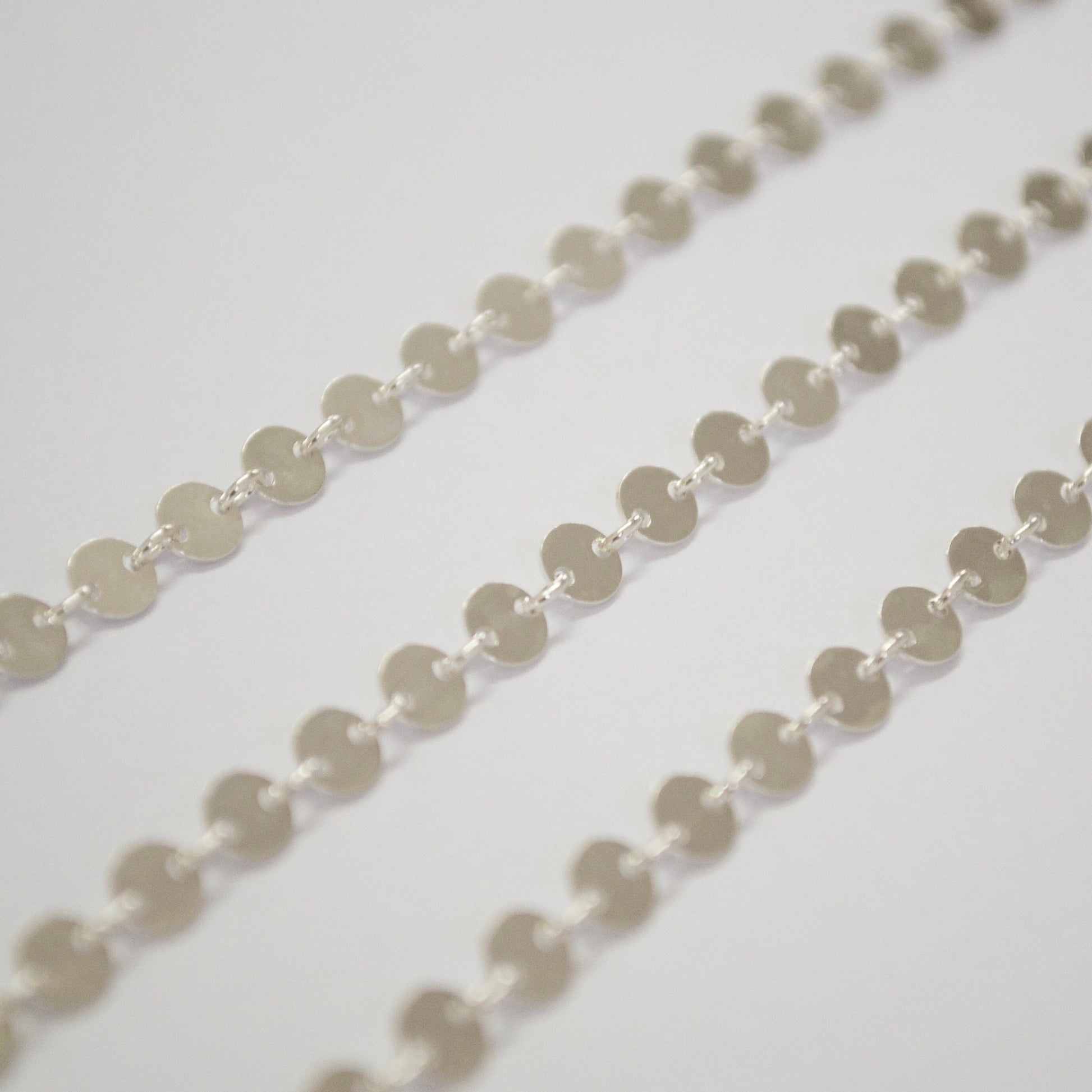 Close-up of a sterling silver circle chain on a light gray background