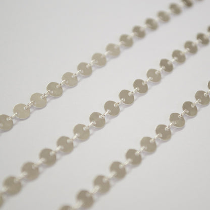 Close-up of a sterling silver circle chain on a light gray background